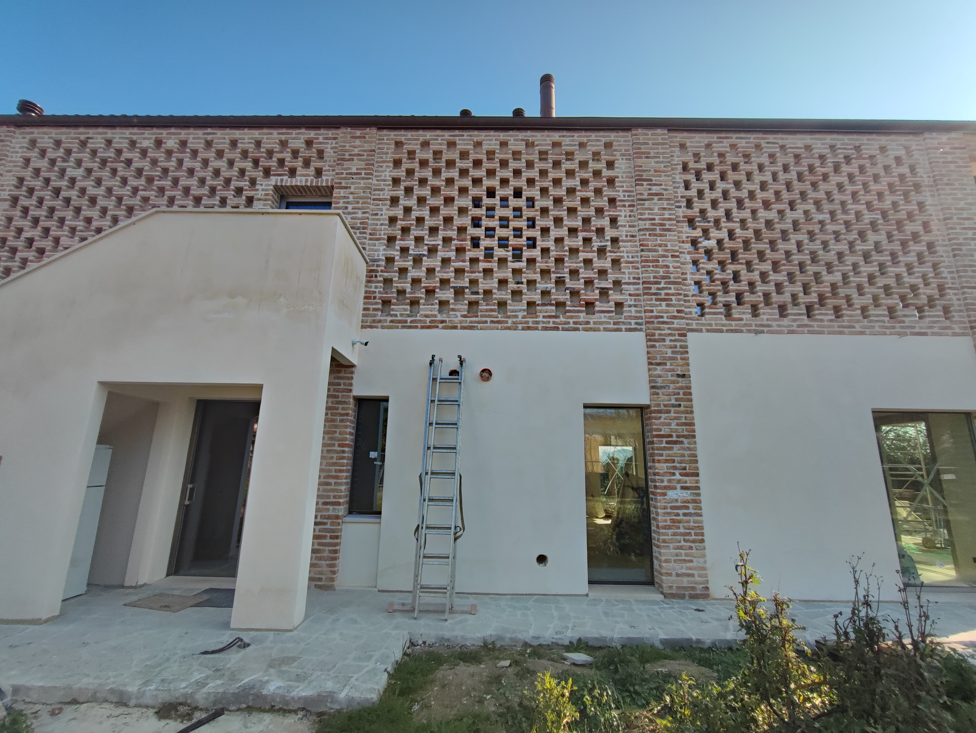 Facciata in mattone facciavista con pattern decorativo traforato